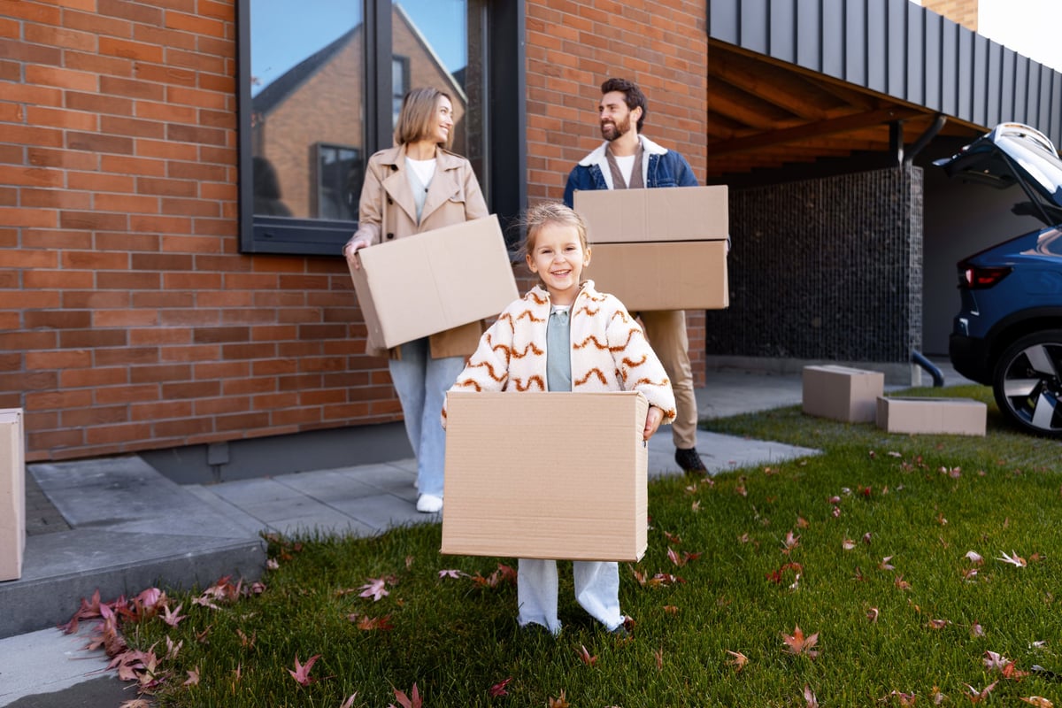 Happy family moving into a new house with cardboard boxes
